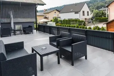 a patio with chairs and tables on a balcony at EnDi Rooms in Ljubljana