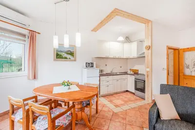 a kitchen and dining room with a table and chairs at Apartma Brešan in Kobarid