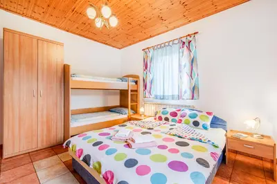 a small bedroom with a bed and bunk beds at Apartma Brešan in Kobarid