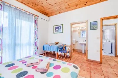 a bedroom with a bed and a table and a bathroom at Apartma Brešan in Kobarid
