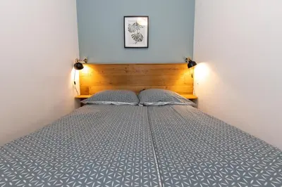 a bed with a wooden headboard in a bedroom at Apartment Muznik in Bled