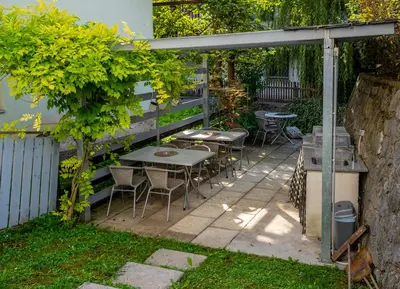 a patio with tables and chairs under a pergola at Apartment Muznik in Bled