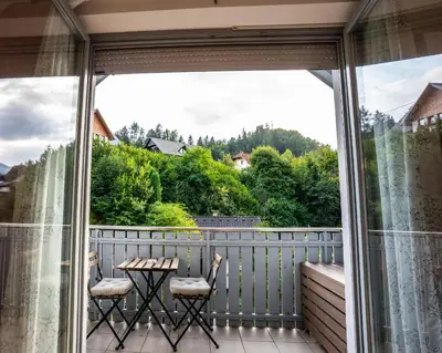 a balcony with two chairs and a table with a view at Apartment Muznik in Bled