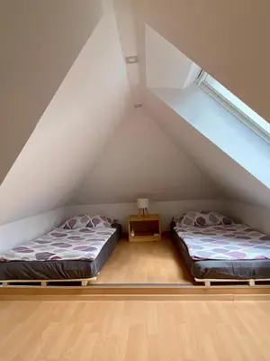 two beds in a room in the attic at Apartment Iris in Bohinj