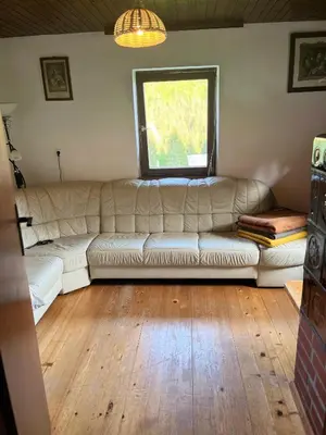 a white couch in a living room with a window at Hiška pri Vrjaku in Bohinjska Bistrica