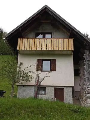 an old house with a wooden roof on a hill at Hiška pri Vrjaku in Bohinjska Bistrica