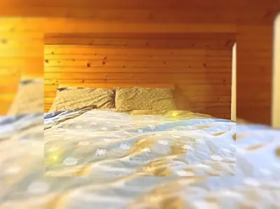 an unmade bed with a wooden headboard in a bedroom at Hiška pri Vrjaku in Bohinjska Bistrica