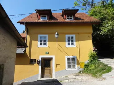 a yellow house with a brown roof at Apartment Tagrajska in Ljubljana