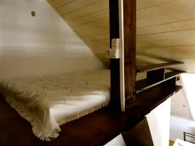 a bed in a room with a wooden stairs at Apartment Tagrajska in Ljubljana