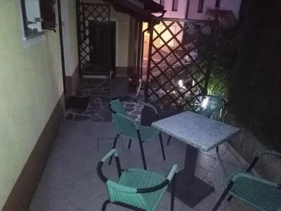 a table and chairs on a balcony at night at Country House Fon in Kobarid