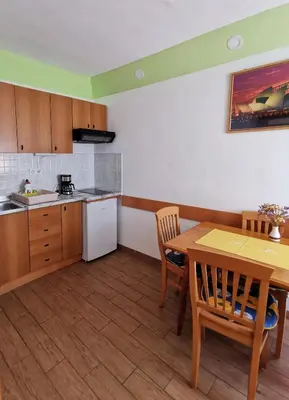a kitchen with a wooden table and a table and chairs at Country House Fon in Kobarid