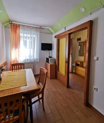 a dining room with a table and chairs and a television at Country House Fon in Kobarid