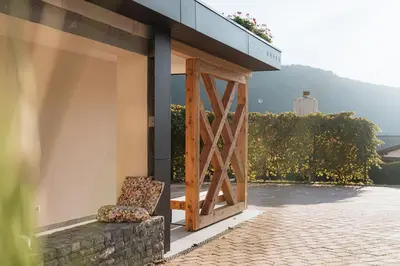 a building with a wooden door and a chair at Hotel Penzion Kobala in Tolmin