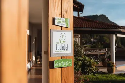 a sign on a pole in front of a building at Hotel Penzion Kobala in Tolmin