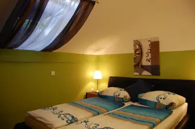 a bedroom with a bed with blue and white sheets and a window at Rooms Hiša Divino in Ptuj