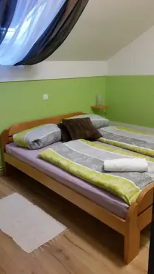 two beds in a room with green walls at Rooms Hiša Divino in Ptuj