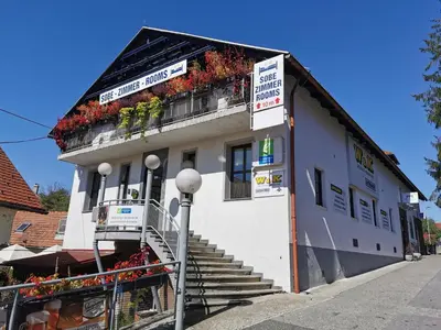 a white building with stairs and flowers on it at Rooms Hiša Divino in Ptuj