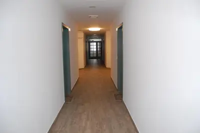 a hallway of an apartment building with a long corridor at Rooms Hiša Divino in Ptuj