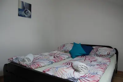 a bed in a room with two cats sleeping on it at Rooms Hiša Divino in Ptuj