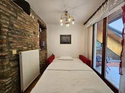 a room with two beds and a brick wall at Apartment Nina with private terrace Tour As Ljubljana in Ljubljana