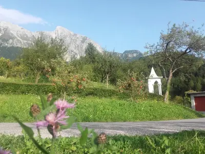 a road with a church and mountains in the background at Apartment Bric in Kobarid