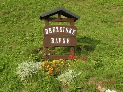 a sign in the middle of a field with flowers at Apartment Bric in Kobarid