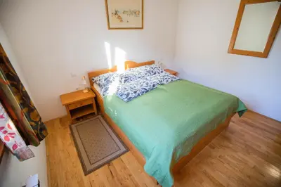 a small bedroom with a bed and a wooden floor at Apartment Jurič in Maribor