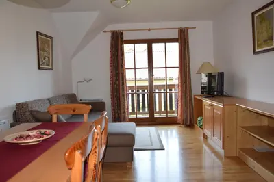 a kitchen and living room with a table and a couch at Apartment Jurič in Maribor