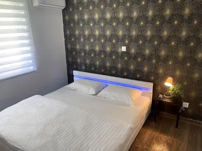 a bedroom with a white bed with a black wall at Apartment in Maribor in Maribor