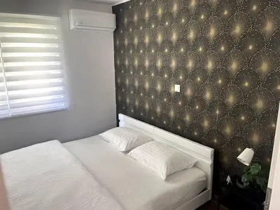 a bedroom with a white bed and a wall with lights at Apartment in Maribor in Maribor