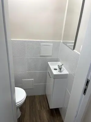a white bathroom with a toilet and a sink at Apartment in Maribor in Maribor