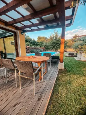 a wooden deck with a table and chairs at Olive garden family apartment with private pool in Sežana