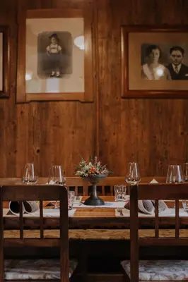 a dining room with a table with wine glasses at Koroška hiša Pri lipi, Boutique hotel in Muta