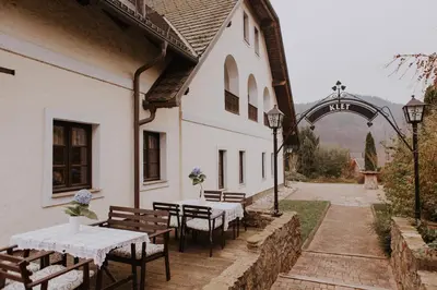 a group of tables and benches outside of a building at Koroška hiša Pri lipi, Boutique hotel in Muta