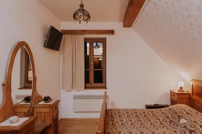 a bedroom with a bed and a mirror and a window at Koroška hiša Pri lipi, Boutique hotel in Muta