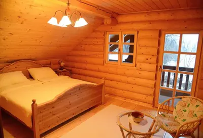 a bedroom with a bed in a log cabin at Luxury Chalet at Podlipje Estate in Tešanovci