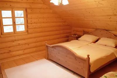 a bedroom with a bed in a log cabin at Luxury Chalet at Podlipje Estate in Tešanovci
