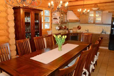 a kitchen with a wooden table with a vase of flowers at Luxury Chalet at Podlipje Estate in Tešanovci