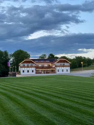 a large grass field in front of a building at Rooms at Podlipje Estate in Tešanovci