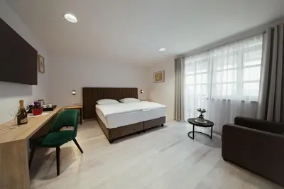 a bedroom with a bed and a desk and a couch at Rooms at Podlipje Estate in Tešanovci