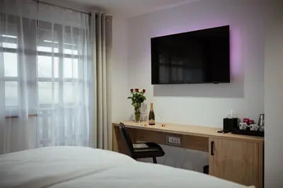 a bedroom with a desk and a television on a wall at Rooms at Podlipje Estate in Tešanovci