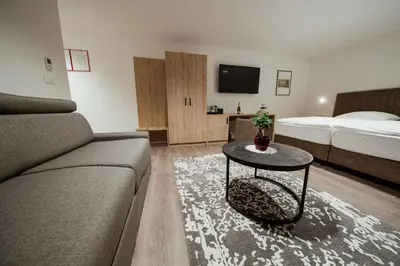 a living room with a couch and a bed and a table at Rooms at Podlipje Estate in Tešanovci