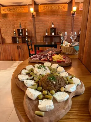 a table with two plates of different types of cheese at Rooms at Podlipje Estate in Tešanovci