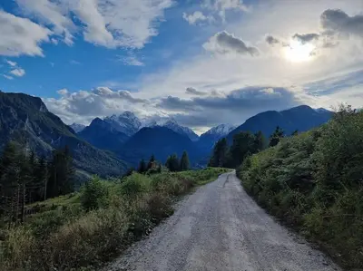 a dirt road with mountains in the distance at Comfy mountain nest in Mojstrana