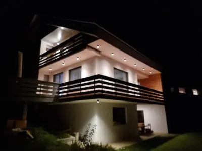 a large building with balconies on top of it at night at Comfy mountain nest in Mojstrana