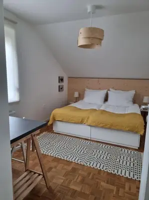a bedroom with a bed with a yellow blanket and white pillows at Comfy mountain nest in Mojstrana
