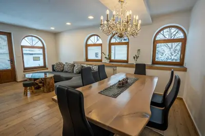 a dining room with a table and a couch at TEMPFER Apartments & Rooms with new WELLNESS in Rateče