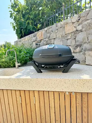 a grill sitting on a table next to a stone wall at Casa Matko in Kostanjevica na Krasu