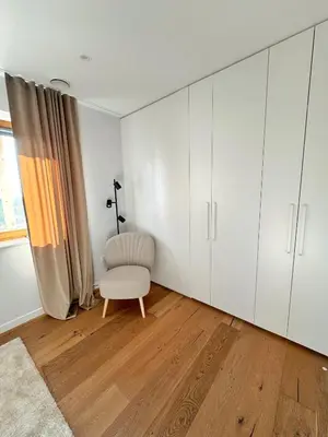 a living room with white cabinets and a chair at Casa Matko in Kostanjevica na Krasu