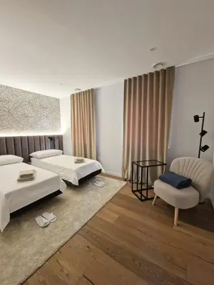 a hotel room with two beds and a chair at Casa Matko in Kostanjevica na Krasu